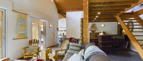 A cozy living room with a sofa, chairs, and a dining area.