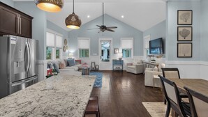 A spacious kitchen with a large island, a dining area with a wooden table, and a living room with a sofa and armchairs. - Close to Dining & Shopping; 1-floor Cottage; Community Pool (Santa Rosa Beach)