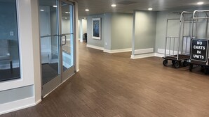 A hallway with glass doors, a 'No Carts in Units' sign, and a cart with wheels.