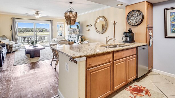 A spacious kitchen with a large island, wooden cabinets, and a built-in dishwasher. - Carols Coastal K502 3 Bedroom Condo by RedAwning (Rockport)