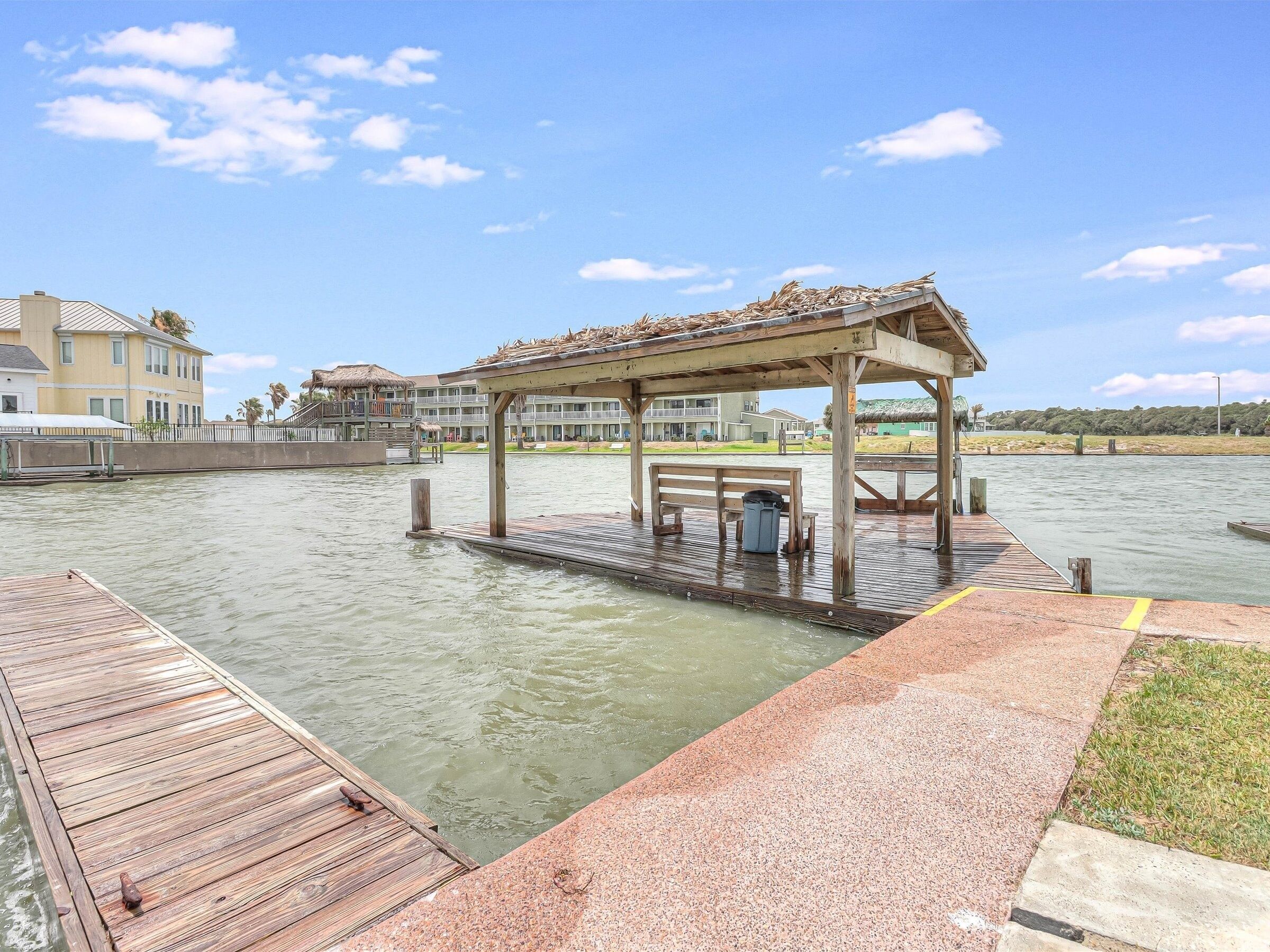 A wooden dock extending into a body of water with a gazebo structure on it.