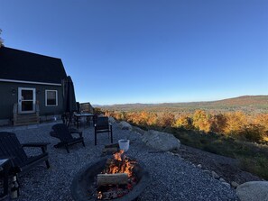A house with a fire pit and outdoor seating. - Sebago Sunrise Limit 8 3 Bedroom Villa by RedAwning (Sebago)