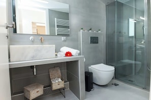 A modern bathroom with a large mirror, a white sink, a glass shower enclosure, and a white toilet. - Pireas Jewel New Design Apt w Backyard (Piraeus)