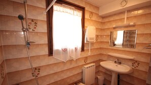 Ein Badezimmer mit Dusche, Toilette und Waschbecken.