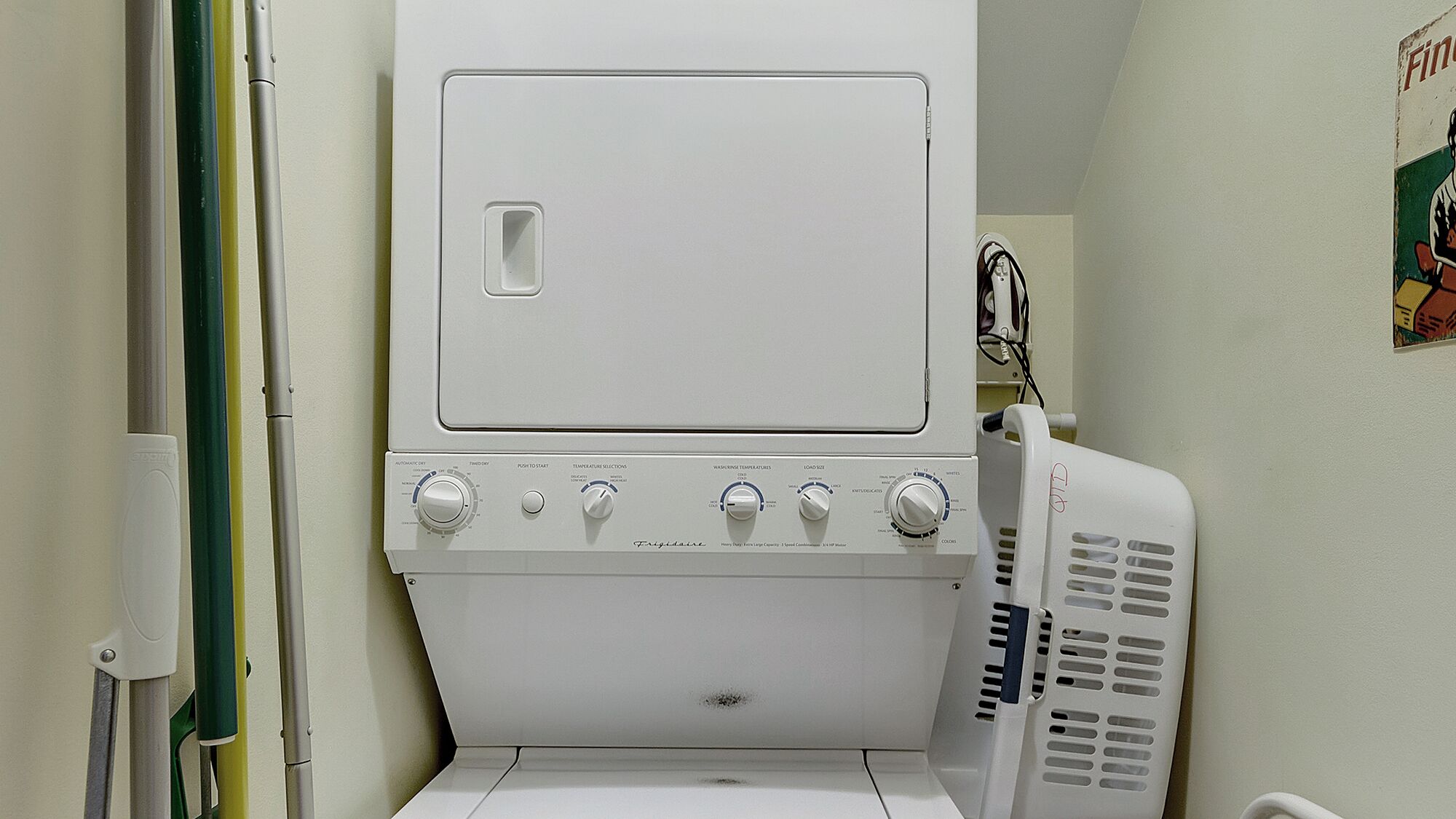 Lavadora secadora compacta, blanca, de carga frontal, con varios mandos y una pequeña ventana de visualización.