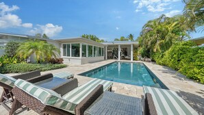 Ein Poolbereich mit Liegestühlen und einer überdachten Terrasse.