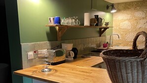 Una cocina con encimera de madera, refrigerador blanco, un fregadero y una cesta.