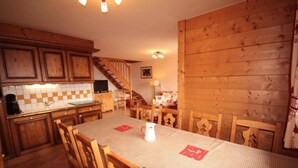 Une cuisine chaleureuse avec des meubles en bois, un pare-feu en carrelage et une table à manger avec des chaises.