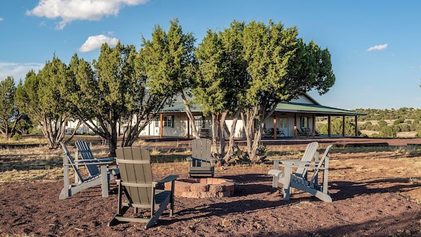 A rustic cabin with outdoor seating and a covered patio area. - Wide open spaces getaway (Concho)