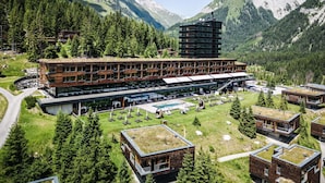 Un hôtel moderne composé de plusieurs bâtiments, doté d’une piscine et situé dans un cadre montagneux.