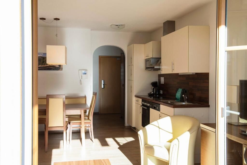 A compact kitchen with a dining area, a microwave, and a coffee maker.