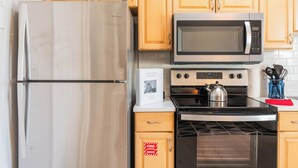 A kitchen with a stainless steel refrigerator, a microwave, and a stove. - Cute & Compact 1BR - Easy Walk to Town (St. Augustine)