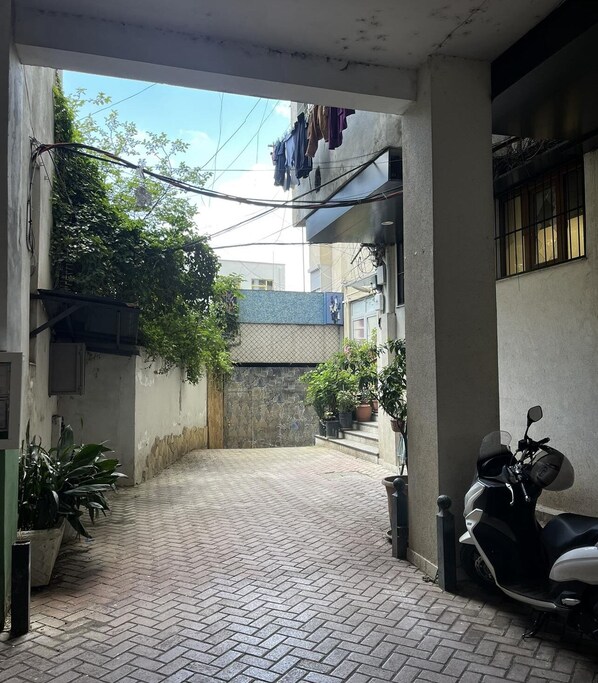 Stroll through this charming courtyard, lined with potted plants and surrounded by buildings with balconies.
