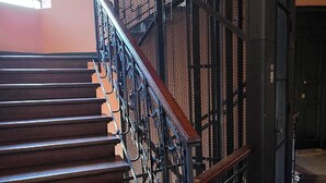 Uma escada com corrimão de metal e degraus de madeira.