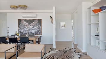 Un interior moderno con comedor, una obra de arte grande y una alfombra de cebra.
