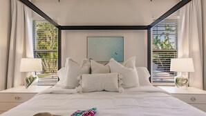 A neatly arranged bedroom with a large bed, two bedside tables, and a window with blinds. - LUXE, Beach, Hot Tub, Putt Putt, 2 Mstr Suites, 3 Kings, Hot Tub, Bunkbds, Pets (Naples)