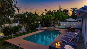 A swimming pool with a hot tub, lounge chairs, and a fire pit. - LUXE, Beach, Hot Tub, Putt Putt, 2 Mstr Suites, 3 Kings, Hot Tub, Bunkbds, Pets (Naples)