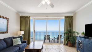 A living room with a sofa, a coffee table, a TV, and a balcony with a view of the ocean. - Fantastic Gulf-front 1 Bd Condo At Boardwalk in Panama City Beach! (Panama City Beach)