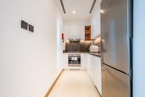 Eine moderne Küche mit weißen Schränken, Edelstahlgeräten und einem eingebauten Backofen.