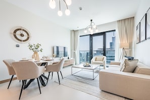 Una sala de estar moderna con comedor, ventanas amplias y vista a la ciudad.