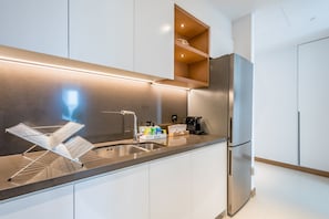 Una cocina moderna con un lavamanos de acero inoxidable, una cafetera y un horno empotrado.