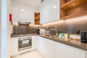 A modern kitchen with a built-in oven, stainless steel appliances, and a coffee machine. - Delightful 2BR Apartment in VIDA Residences Dubai Marina by Deluxe Holiday Homes (Dubai)