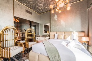 Ein modernes Hotelzimmer mit einem großen Bett, einem Schminktisch mit Spiegel und einem außergewöhnlichen Deckenstil.