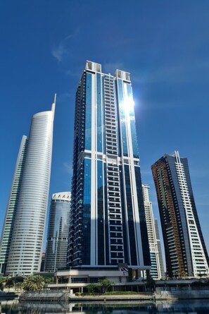 Ein Hochhaus mit modernem architektonischen Design, gekennzeichnet durch eine markante vertikale Struktur und eine reflektierende Glasfassade.