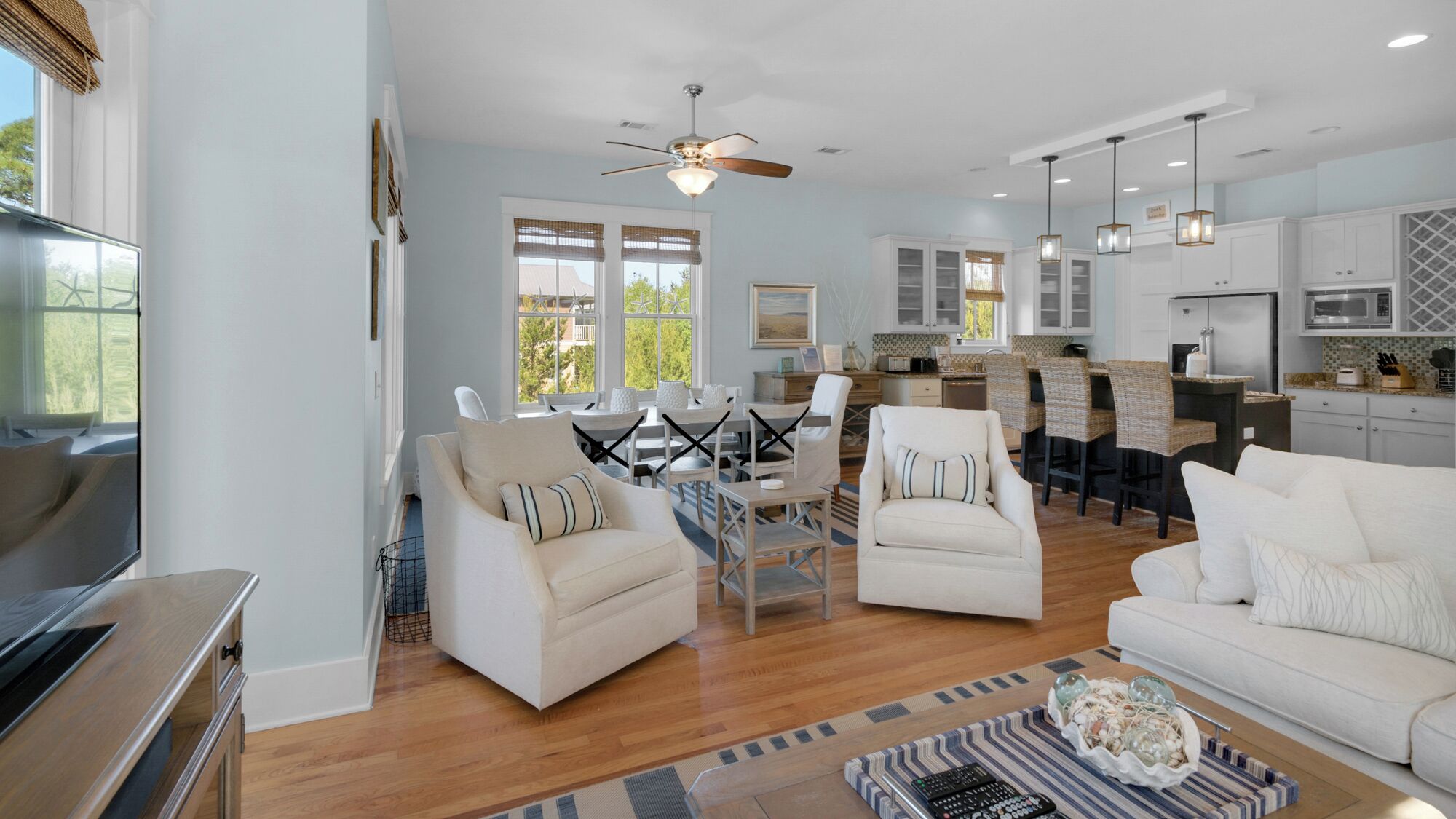 A spacious living area with a dining table, two sofas, and a kitchen in the background.