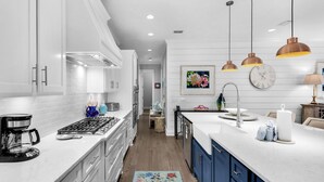 A modern kitchen with white cabinets, stainless steel appliances, and a central island with a sink. - Grayton Beach - Gated Community With 2 Pools & Tennis (Santa Rosa Beach)