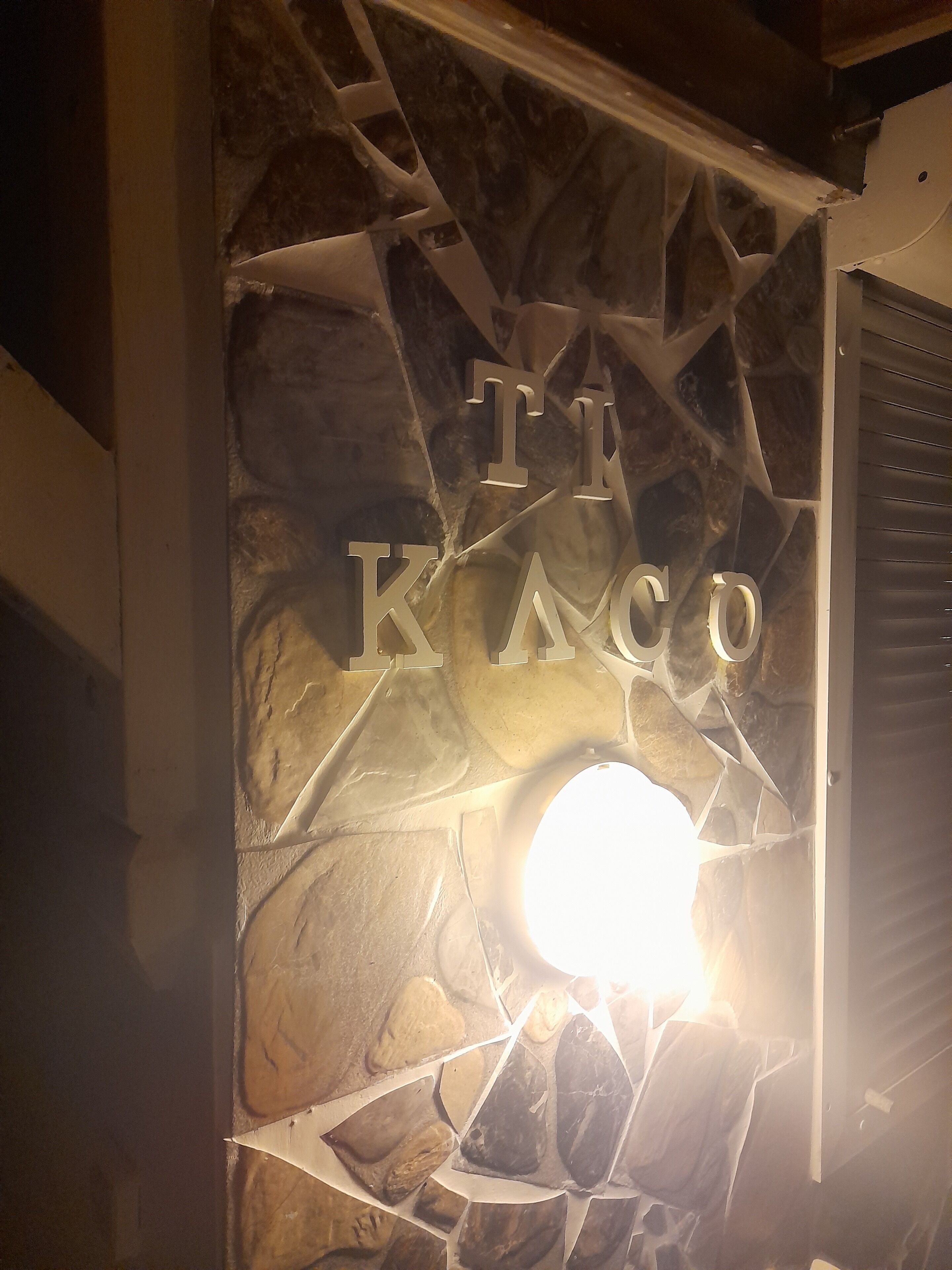 Eine steine Mauer mit einem ausgeschnittenen Schild, auf dem ‘TE KACO’ steht.