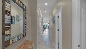A hallway with a bench, framed artwork, and a door leading to another room. - Gulf Front in Seagrove - Amazing Views - Easy Beach Access, Pool (Santa Rosa Beach)