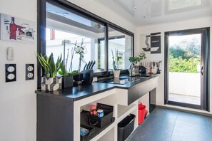 Una cocina moderna con un espejo grande, estantes empotrados y vistas al exterior.