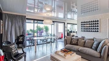 Un salon moderne comprenant un canapé, une table basse et un coin repas avec des chaises et une table.