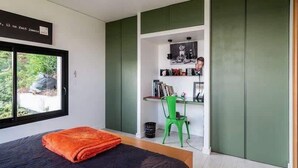 A bedroom with a bed, a desk with a chair, and a wardrobe.