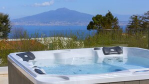 Un bain à remous offrant une vue dégagée sur une montagne et un plan d’eau en arrière-plan.