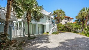 A gated residential area with a private pool, palm trees, and a clear sky. - Gulf Front With Private Pool, Sleeps 21, Amazing Decks, Free Beach Setup! (Santa Rosa Beach)