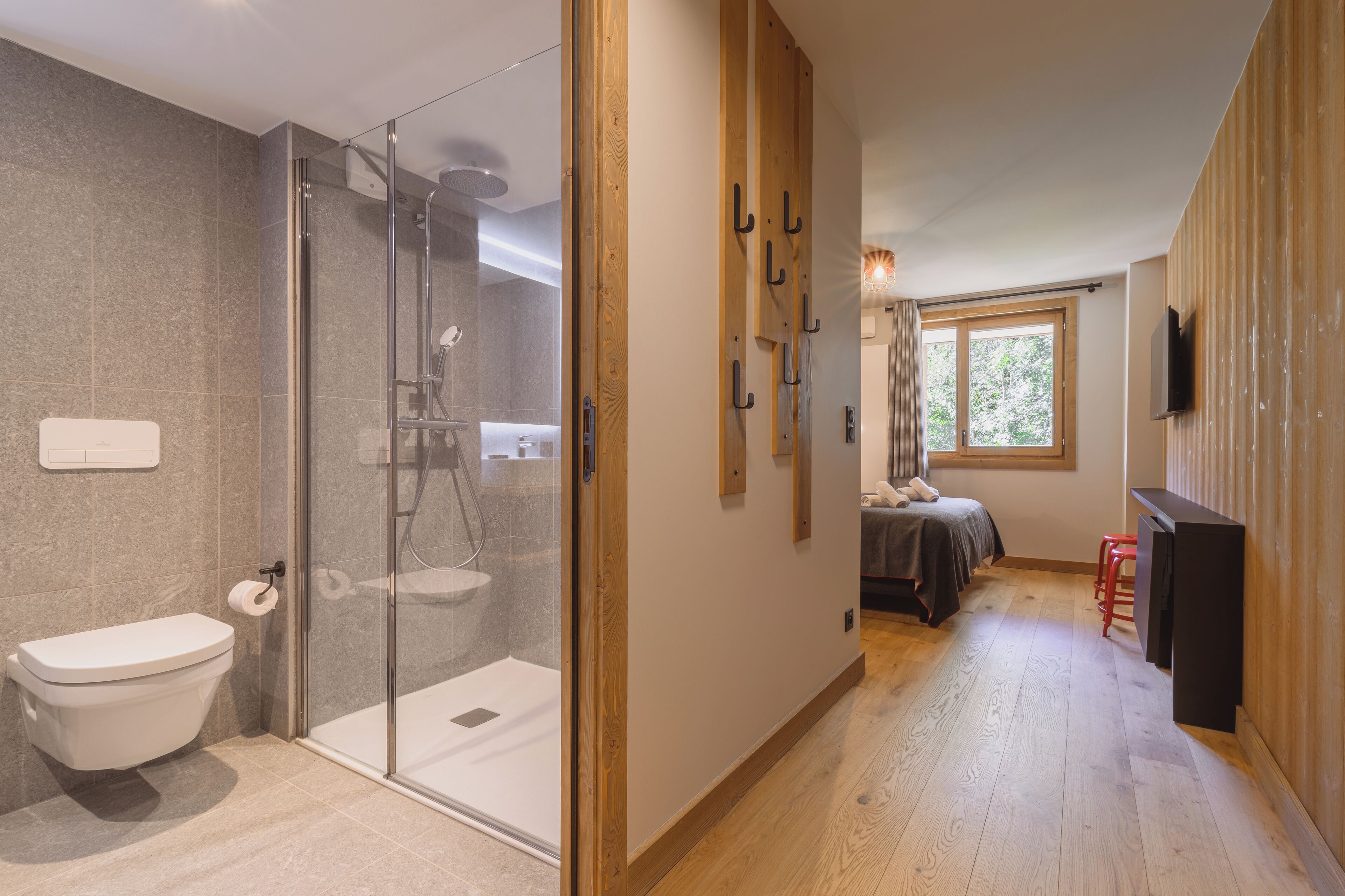 A modern bathroom with a glass shower enclosure, a toilet, and a sink.