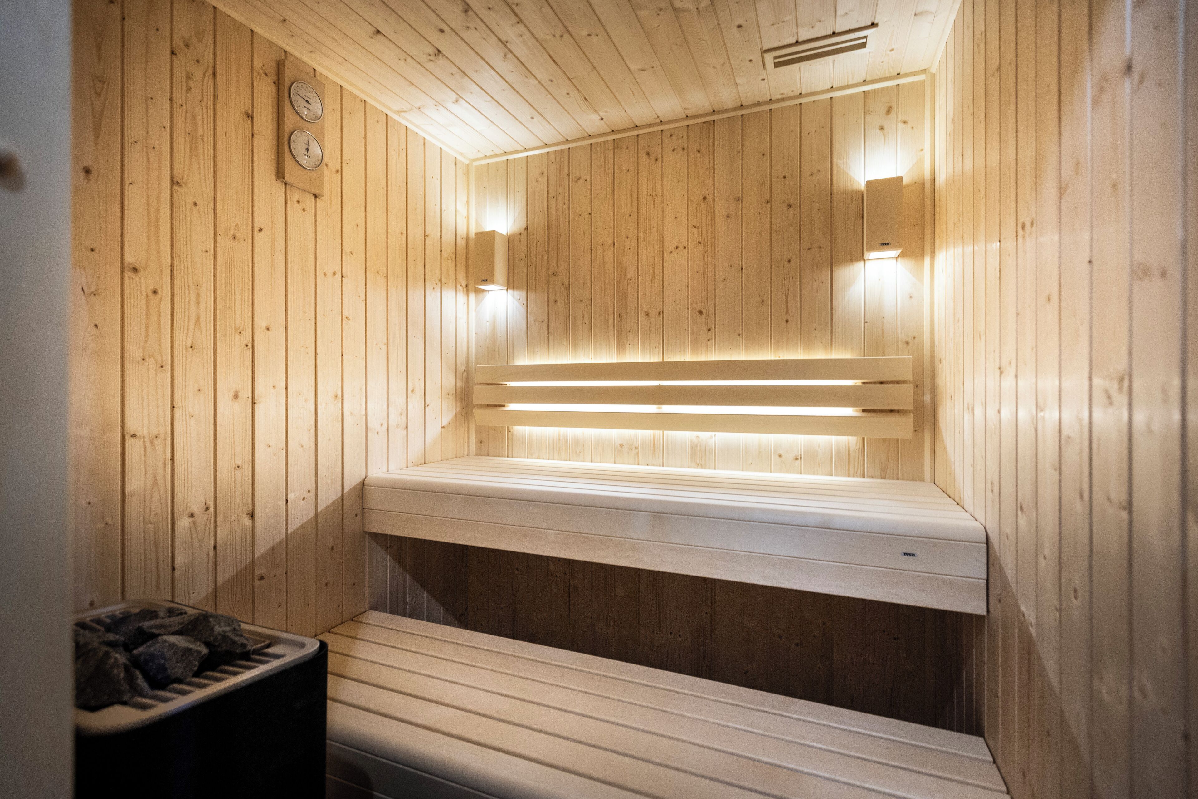 Una sauna de madera con bancos y un asiento.