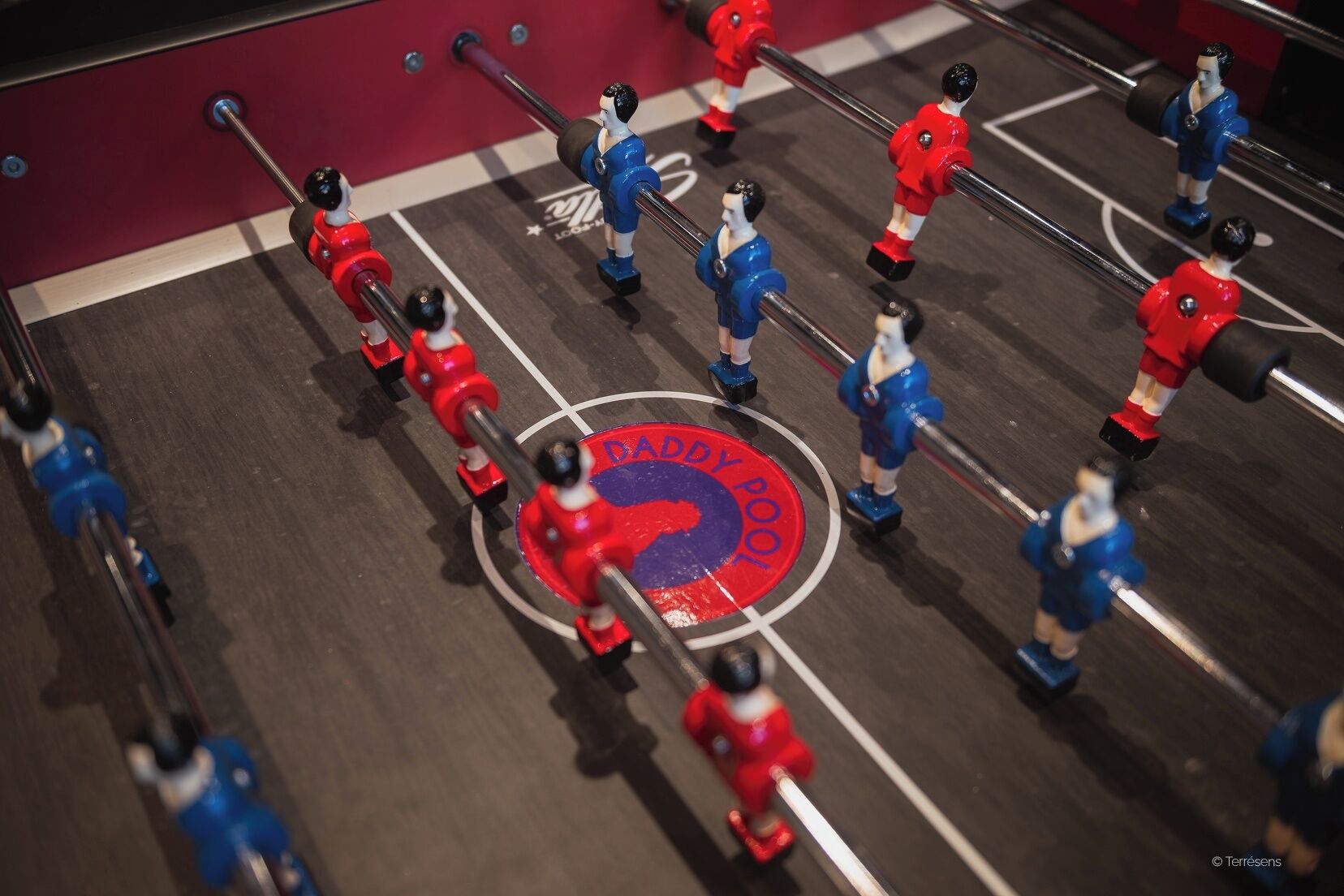 Una mesa de fútbol de mesa con jugadores con uniformes rojos y azules.