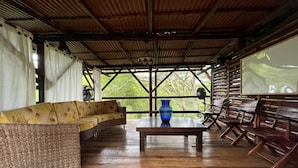 A covered outdoor seating area with a sofa, a table, and chairs. - Ecocabañas Pereira (Pereira)