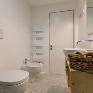 A modern bathroom with a toilet, bidet, and a large mirror above the sink. - Casa Sineo by Wonderful Italy (Turin)