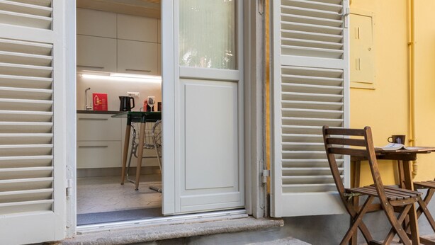An open door leading to a kitchen with a dining area visible.
