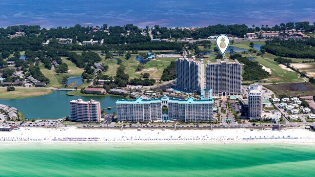 Um resort costeiro com vários hotéis altos, uma orla e um campo de golfe.