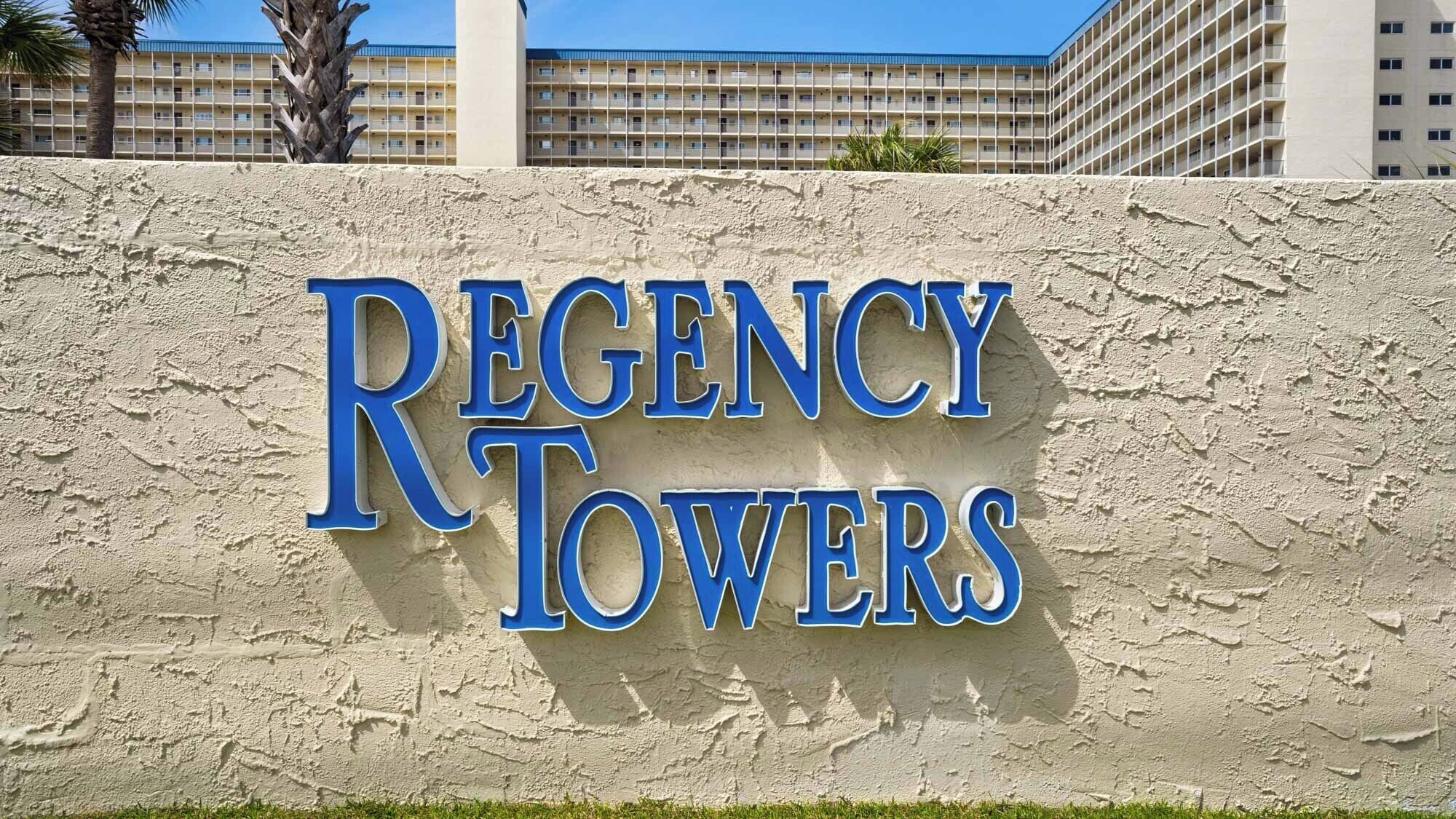 Letrero de Regency Towers sobre un fondo de pared texturizada.