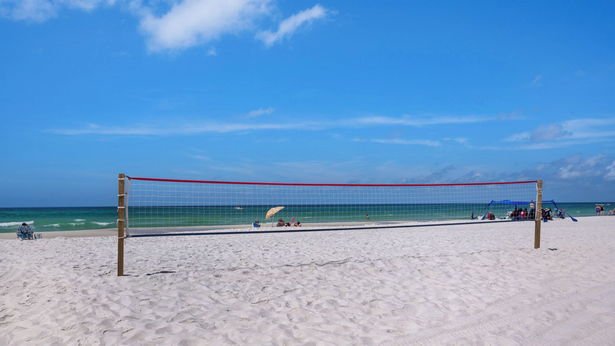 Una rete da pallavolo sulla spiaggia, con cielo sereno.