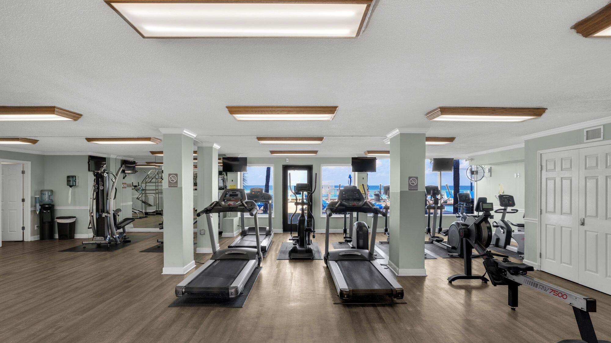 Ein Fitnessstudio mit Laufbändern, Crosstrainern und Gewichten.