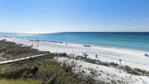 A beach with a wooden walkway, beach chairs, and umbrellas. - Gulf-front in Destin! Community Pool, Minutes to Beach (Destin)