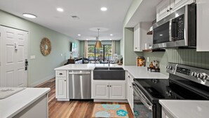 A modern kitchen with white cabinetry, stainless steel appliances, and a central island. - 1BD Bayside Condo at Sandestin, Golf Cart & Pool (Miramar Beach)