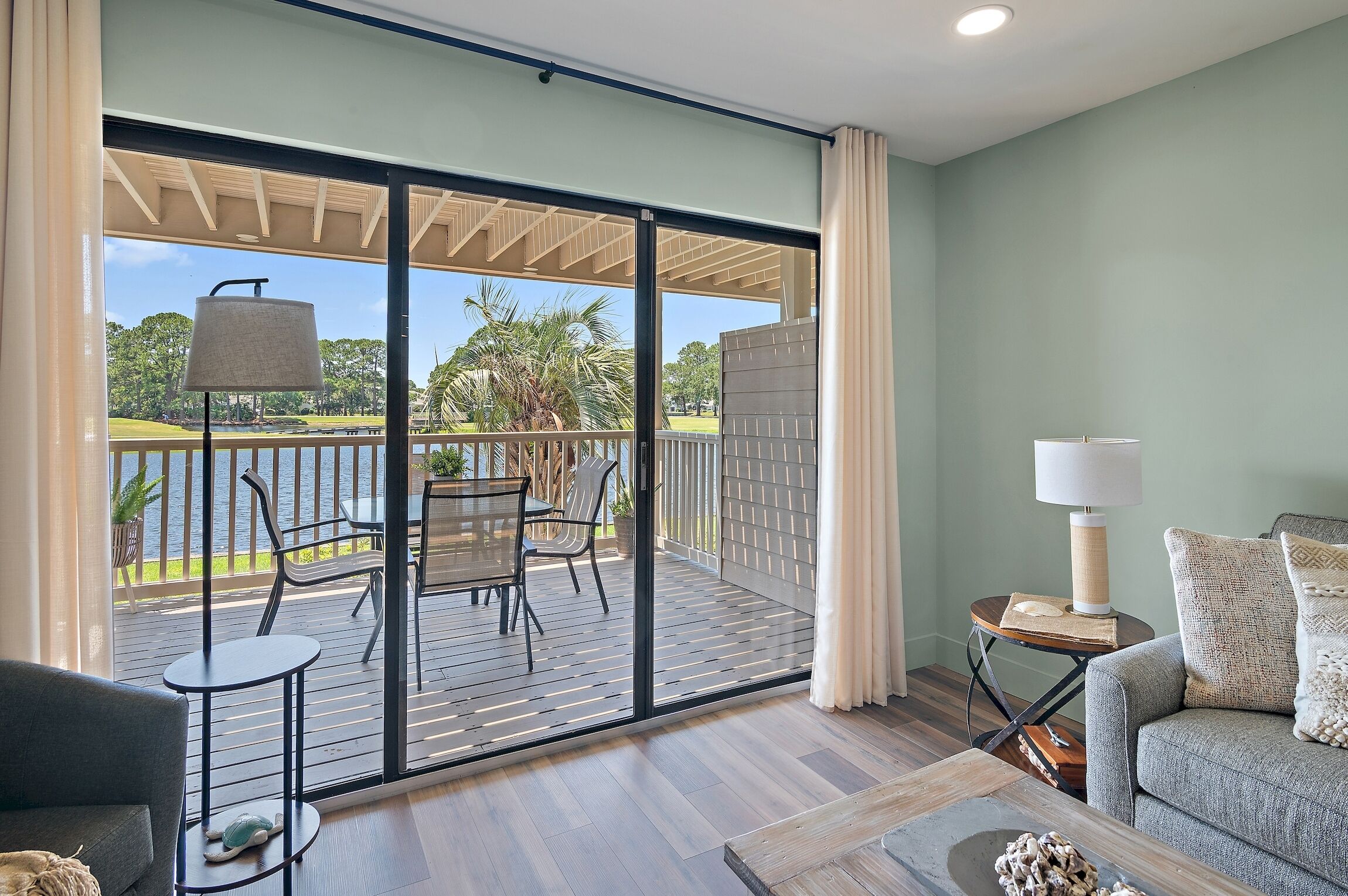 A balcony with a table and chairs, a sofa, and a lamp.